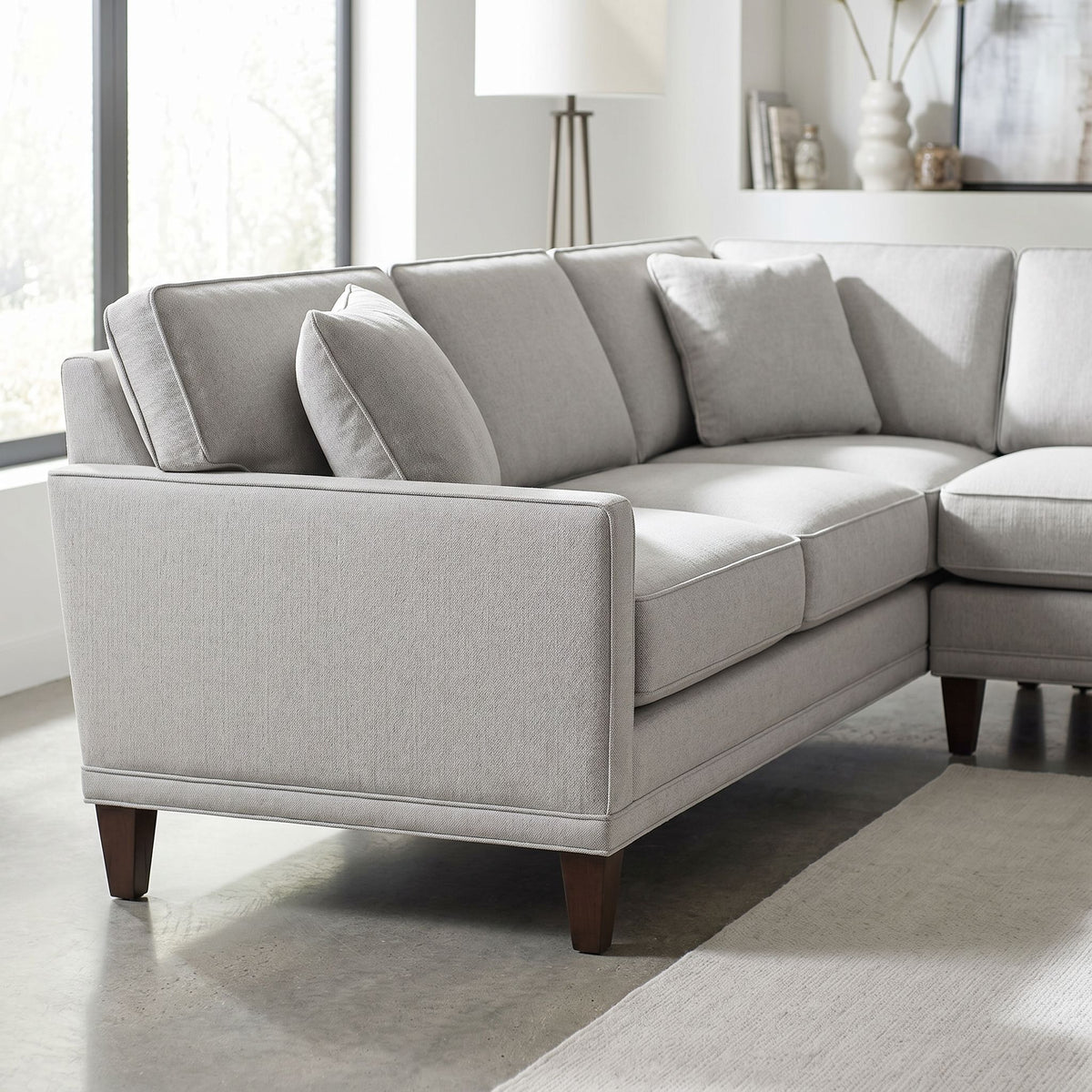Eye-level image focusing on stitching and cushion details of Townsend Sectional in bright modern living space with natural light.