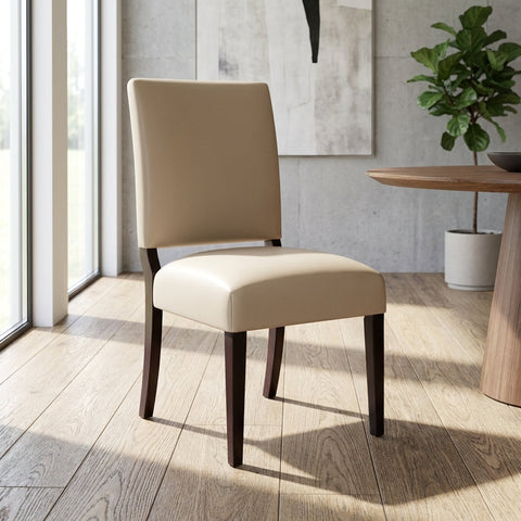 Full-body view of the ClairLeather Chair in a modern dining room, highlighting sleek lines, handcrafted wood, and elegant ambiance in natural daylight.