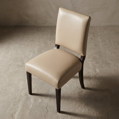 Overhead view of the ClairLeather Chair against a neutral textured backdrop, showing refined craftsmanship, clean lines, and premium materials with sharp focus.