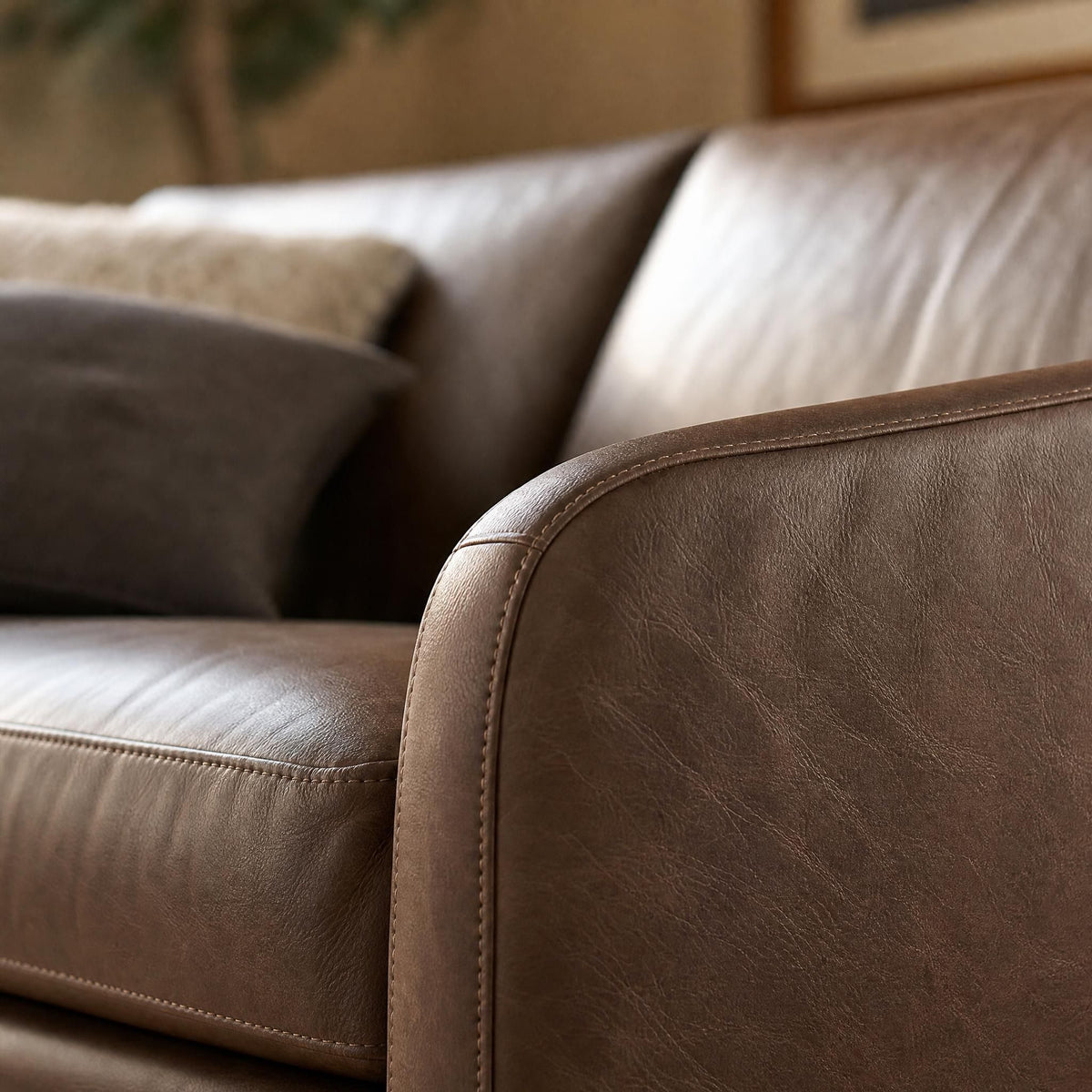 Macro shot of the Frannie Leather Sofa's upholstery focusing on grain, stitching, and subtle creases.