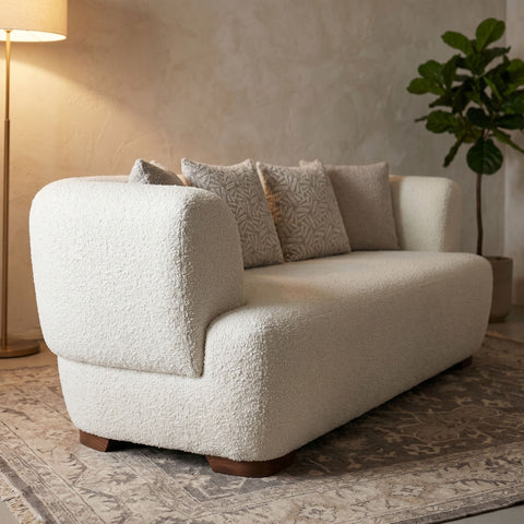 Close-up of Huxley sofa showcasing stitch details and fabric weave in a cozy reading nook with soft ambient lighting.