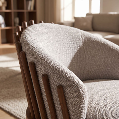 Close-up of Reveal Chair highlighting curved backrest and soft bouclé fabric upholstery in a cozy interior.