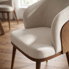 Close-up of Laurent Dining Chair showing upholstered seat and backrest with fabric texture in a well-lit dining room.