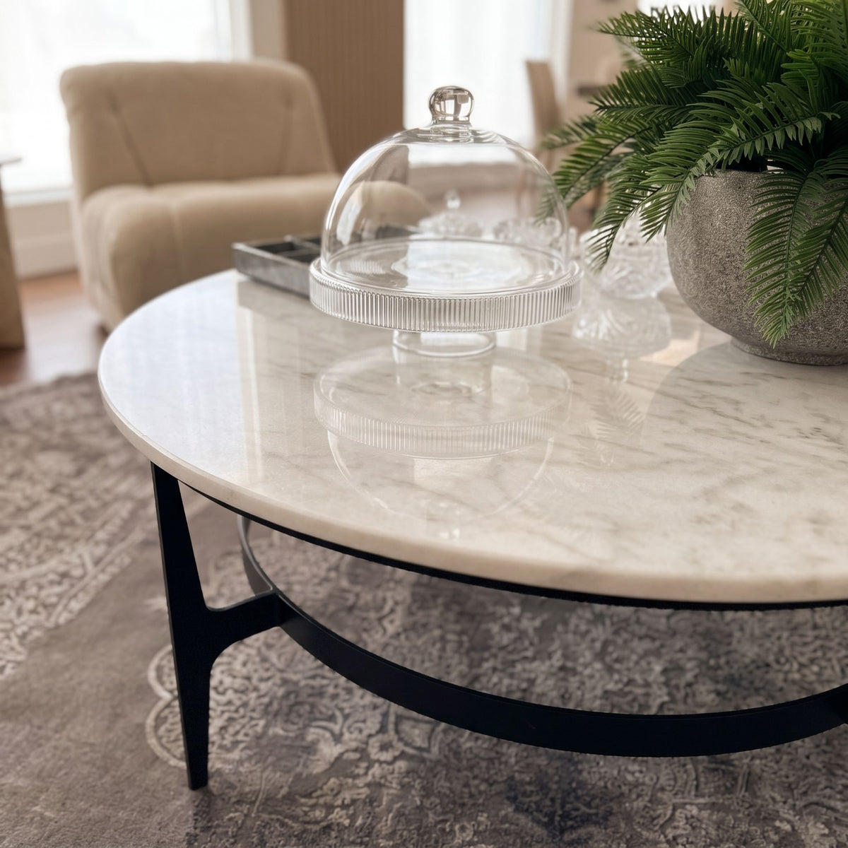 Close-up of Dena Coffee Table's white marble top with detailed veining and polished surface, in a modern living room setting.