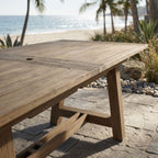 Close-up of the Coastal Teak Dining Table showing wood grain, rustic grooves, and seamless extension with hidden butterfly leaf mechanism.