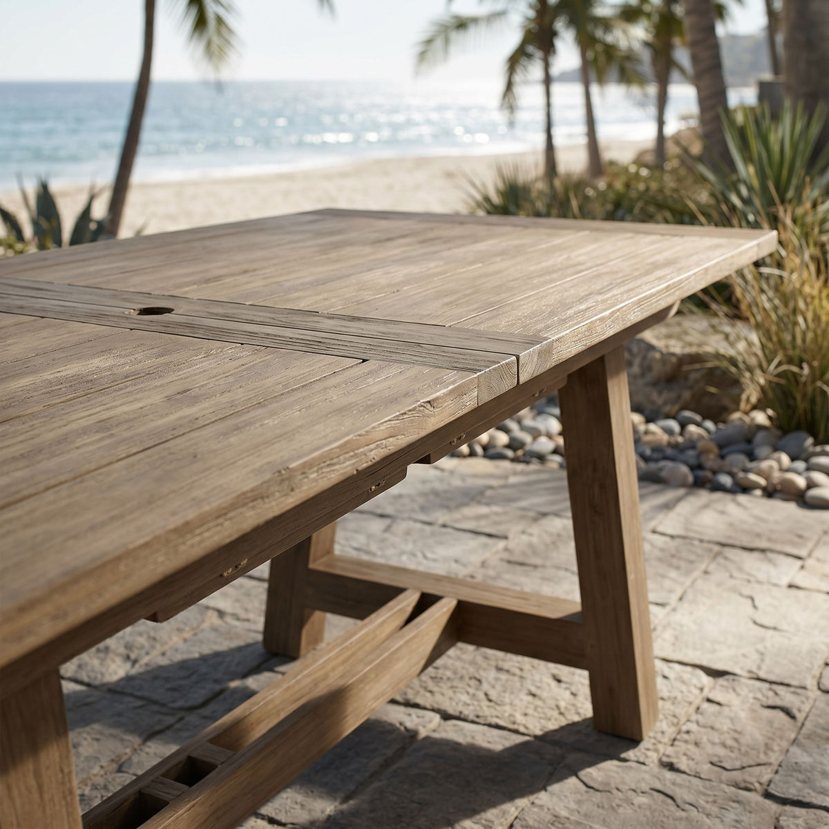 Close-up of the Coastal Teak Dining Table showing wood grain, rustic grooves, and seamless extension with hidden butterfly leaf mechanism.