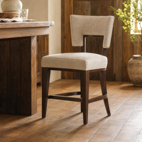 Mid-length shot of Barrow fabric counter stool against rustic background highlighting craftsmanship.