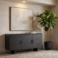 Scene of the Silvanos Sideboard in a stylish living room with a large plant, warm diffuse lighting, and soft shadows emphasizing its dark finish.