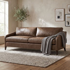 Front view of the FRANNIE LEATHER SOFA in a contemporary open-plan living area, emphasizing its softness and inviting design.