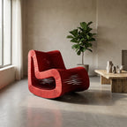 Full-body view of the Seat Belt Rocking Chair in a minimalist living space, showcasing its stiletto profile and woven straps on a wooden frame.
