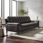Full view of Kandor Leather Sofa in a contemporary living room highlighting its sleek profile, angular arms, and textured dark leather.