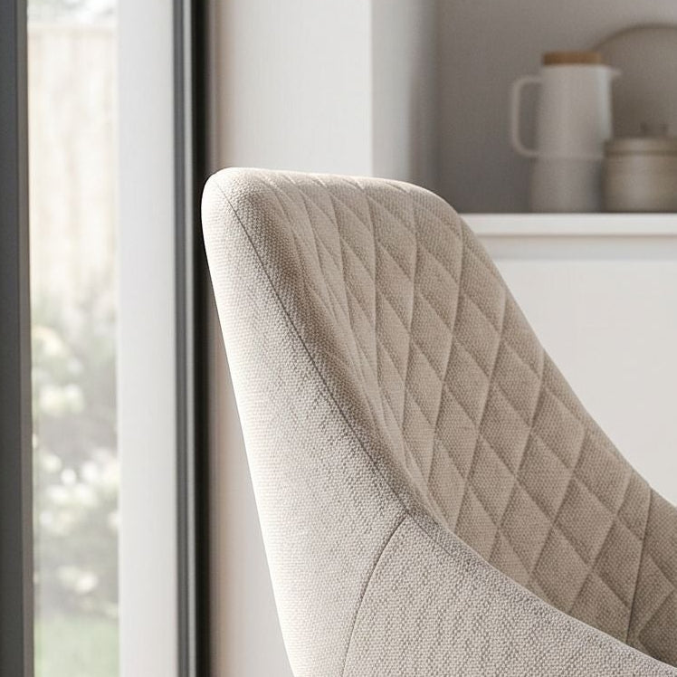 Side perspective of Herchel Dining Chair showcasing curved wooden legs and seamless upholstery in a contemporary kitchen setting with daylight.