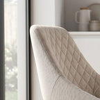 Side perspective of Herchel Dining Chair showcasing curved wooden legs and seamless upholstery in a contemporary kitchen setting with daylight.