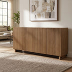 Kellem 4 Door Cabinet with fluted doors and black accent stretcher displayed in a modern living room with natural sunlight.