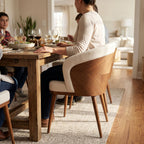 A person seated in Laurent Dining Chair during family dinner with warm natural lighting and inviting atmosphere.