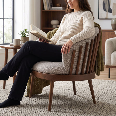 Person seated in Reveal Chair in a cozy living space, highlighting plush bouclé fabric and inviting design.