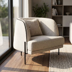Giroud Chair in a modern living room corner with natural sunlight, showcasing its upholstered fabric and clean lines.