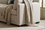 Full scene of Sylvie Bench Seat Sectional in a modern living room with textured wall and ambient daylight.