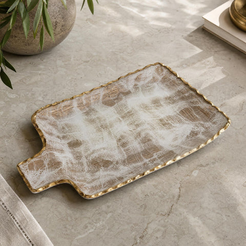 Large gold brushed tray with gold border seen from above on a matte stone countertop in an elegant environment.