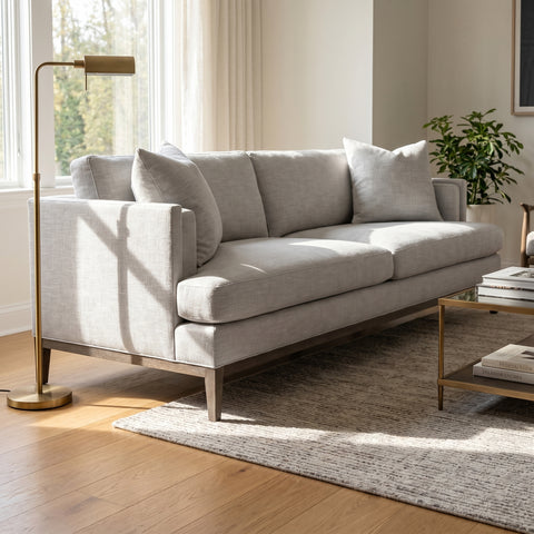 Full-body view of the Peretti 92' sofa in a cozy, modern living space with elegant decor, plush pillows, and natural sunlight.