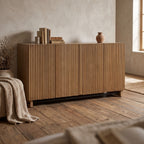 Kellem 4 Door Cabinet featuring fluted doors and black accent in a rustic-inspired interior with warm ambient lighting.