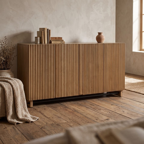 Kellem 4 Door Cabinet featuring fluted doors and black accent in a rustic-inspired interior with warm ambient lighting.