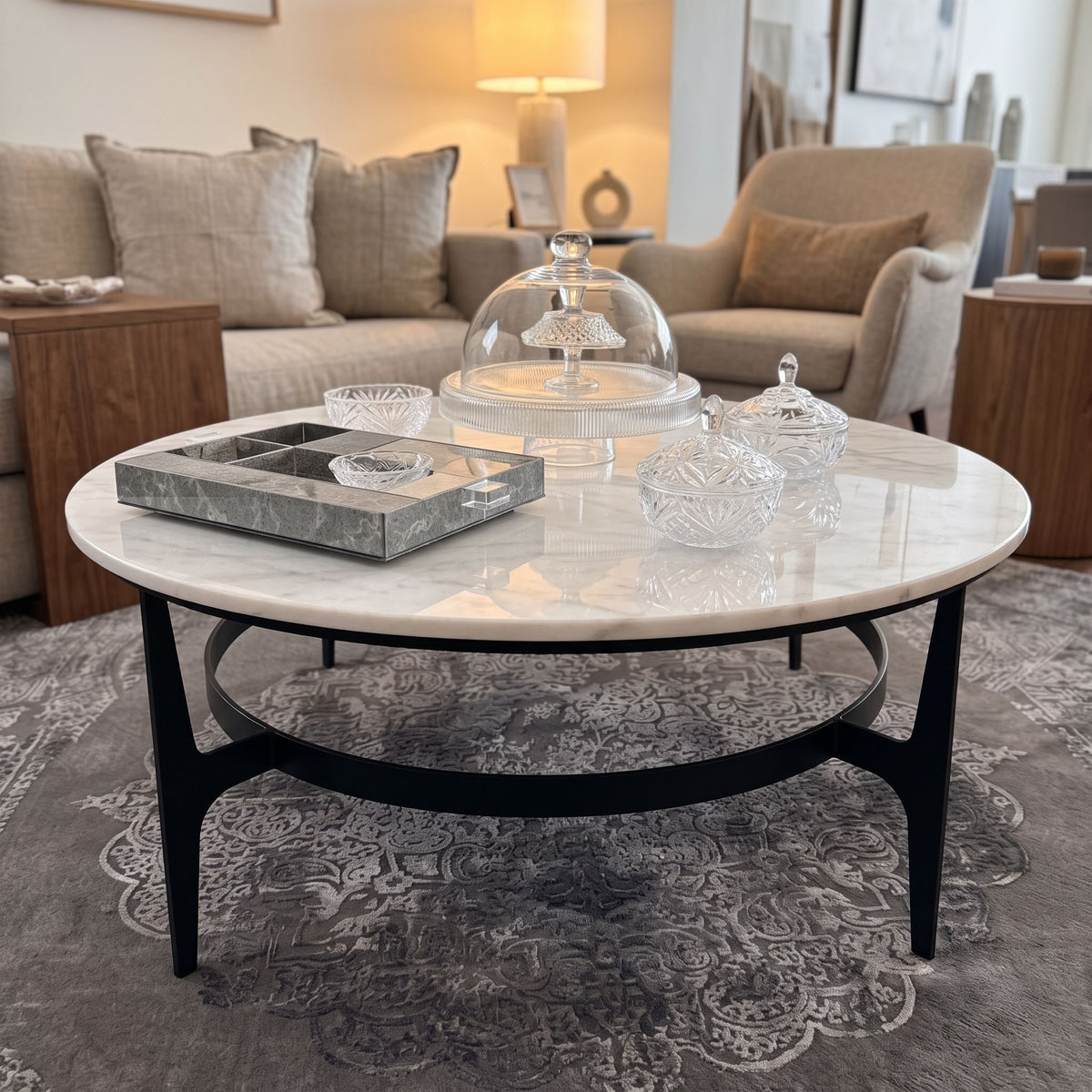 Side angle of Dena Coffee Table in a stylish lounge, highlighting marble veining and organic black metal base.