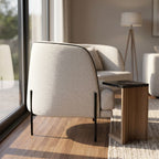 Side profile of Giroud Chair next to a modern side table, emphasizing its elegant shape and clean lines in a bright airy space.