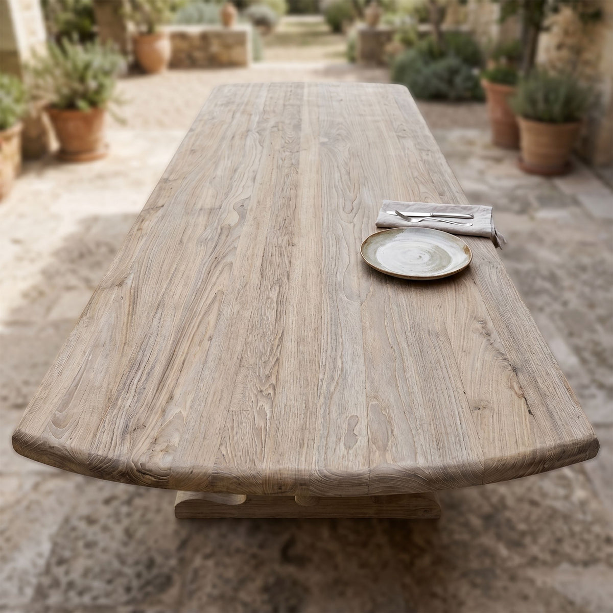 Top-down view of teak table surface focusing on grain and weathered finish, ideal for outdoor dining.