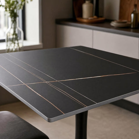 Close-up of Valli square dining table's sintered stone tabletop highlighting texture and durability in a modern kitchen setting.